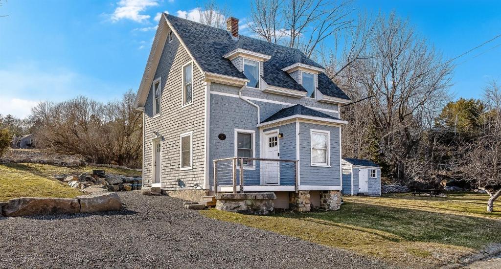 a blue house on a gravel driveway at Acadia View Cottage Peaceful, Pet Friendly, Fire Pit, Near Peaks and Echo Lake in Hall Quarry