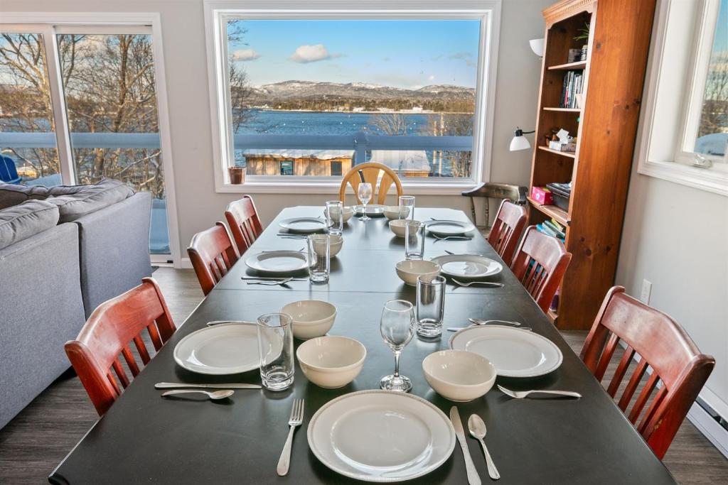 a dining room with a table with plates and wine glasses at Phoenix Aerie Birds-Eye Harbor Views, Maritime Loft, Harbor Watch Sunrise Deck in Southwest Harbor