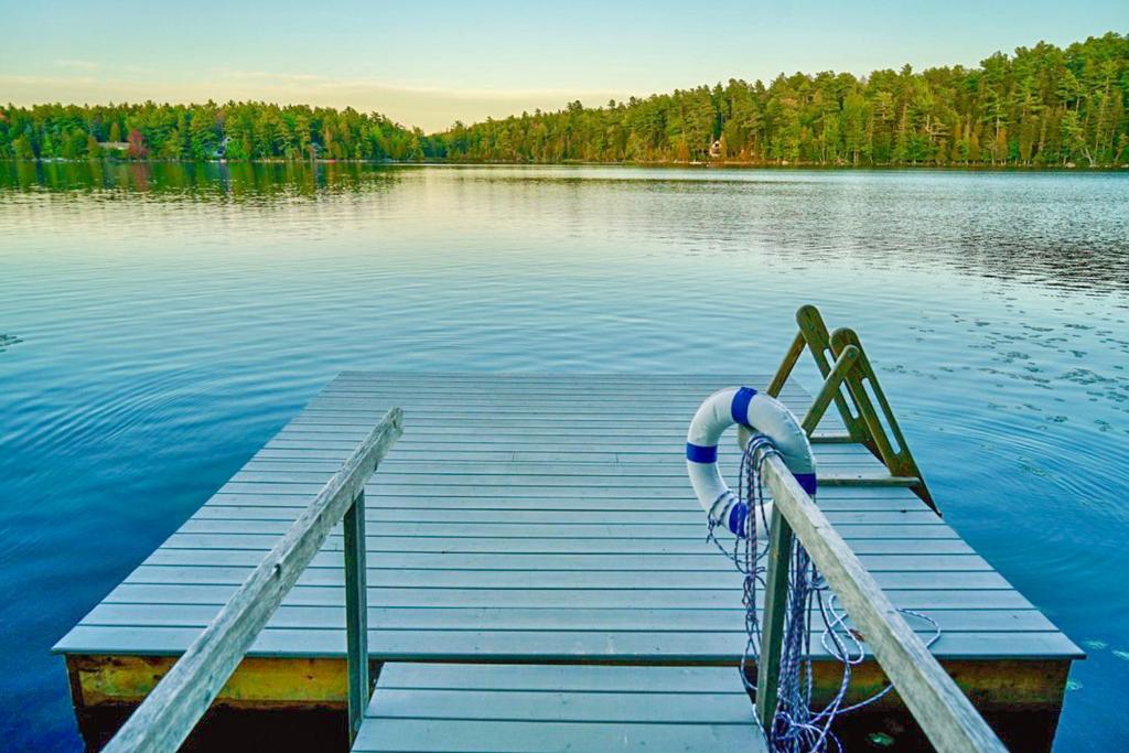 a dock on a lake with aitatingitatingitatingitatingitatingitatingitatingitatingitating at Northern Nest MDI Lakefront Single-Level, Dual King Bedrooms & Private Dock in Pretty Marsh