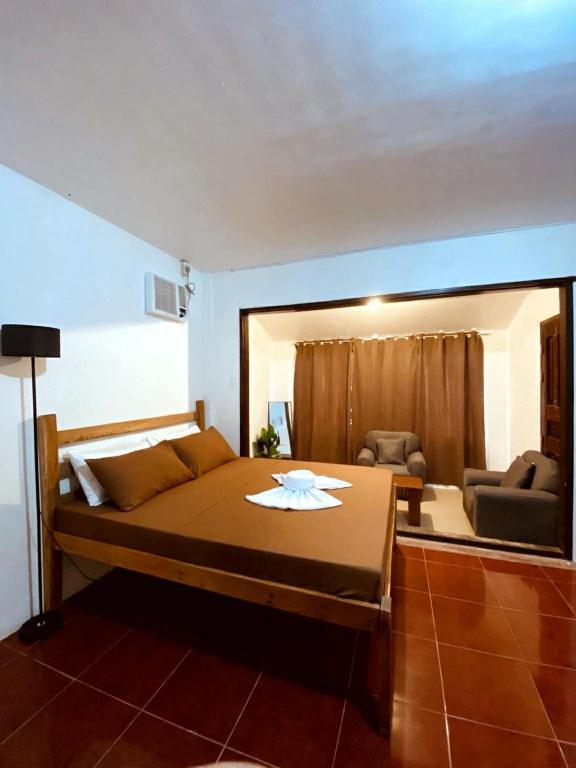 a bedroom with a large bed and a living room at Flo Island Home in General Luna