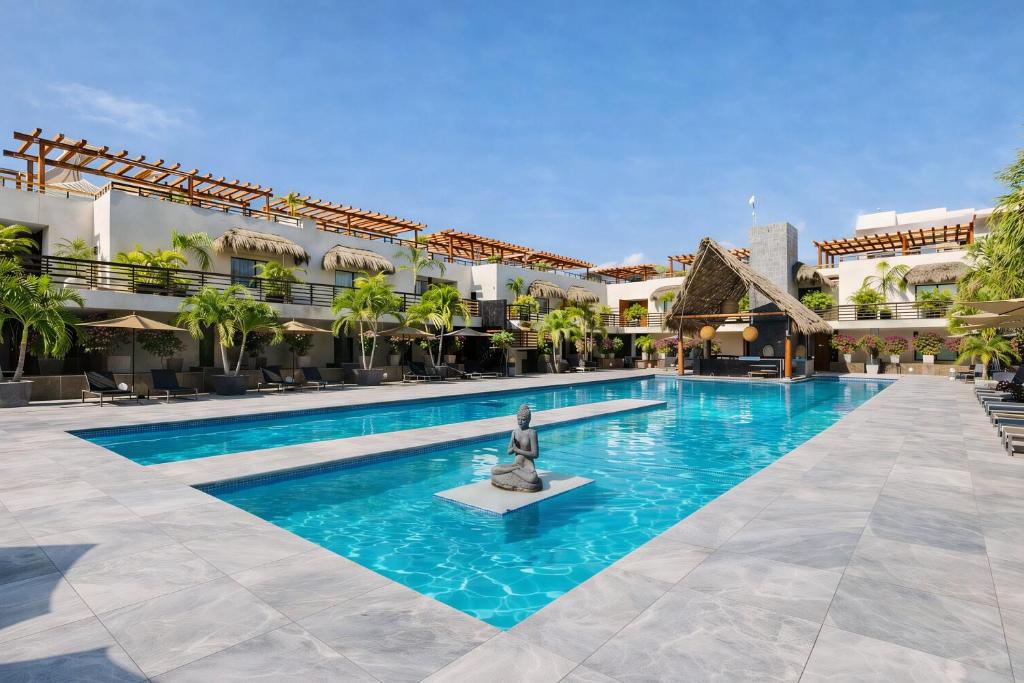 a pool at a resort with a statue in the middle at Aldea Thai Studios Steps to Beach and 5th Ave in Playa del Carmen