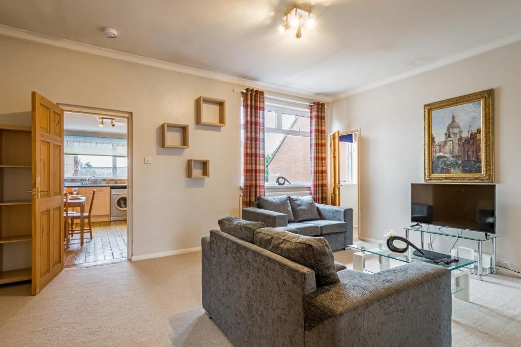 uma sala de estar com um sofá e uma televisão em Linslade Apartment - for Groups and Contractors em Leighton Buzzard