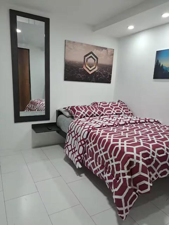 a bedroom with a bed and a mirror at Hotel Chemy in Quito