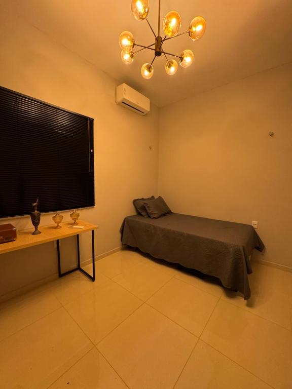 a room with a bed and a tv and a table at Casa Belchior in Sobral