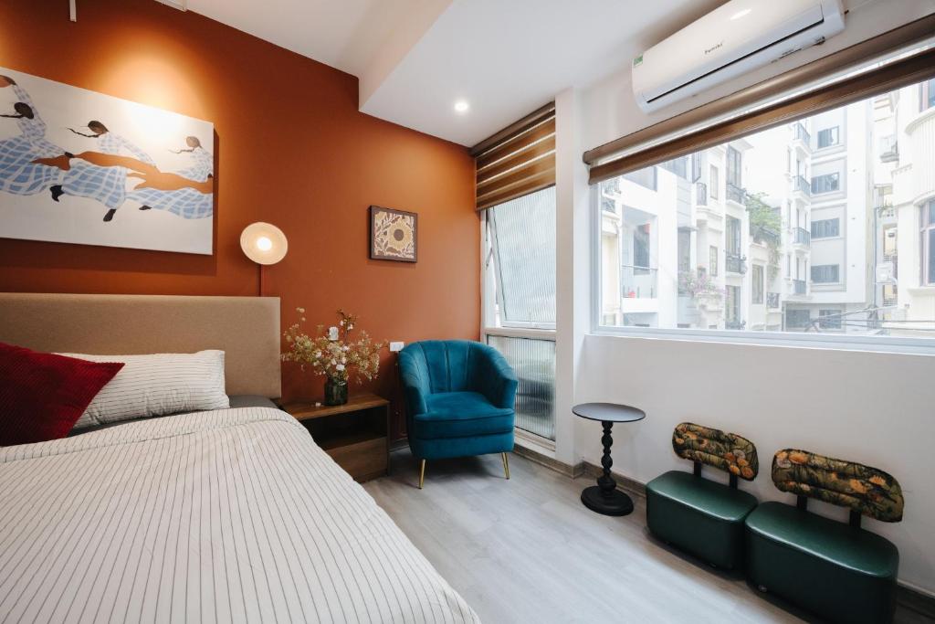 a bedroom with a bed and a chair and a window at Anchie Maison Hà Nội in Hanoi
