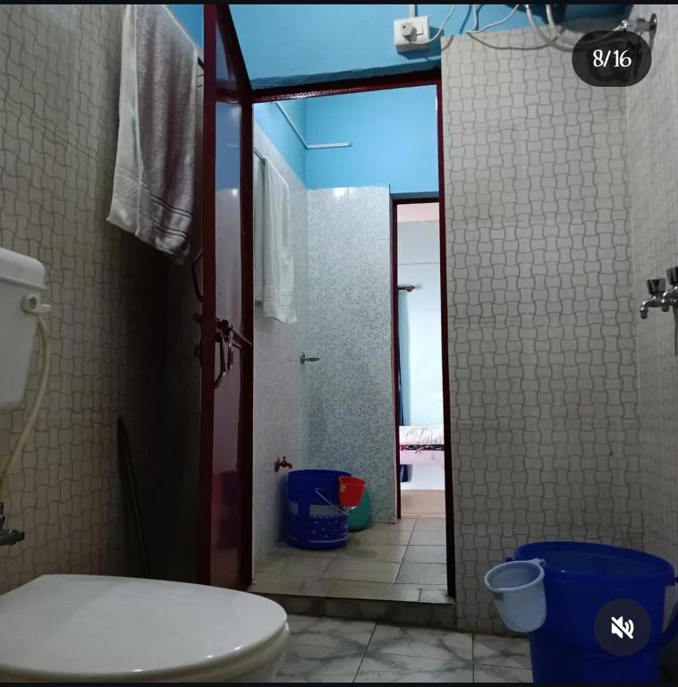 a bathroom with a white toilet and a shower at Harender nayal homestay in Bhīm Tāl