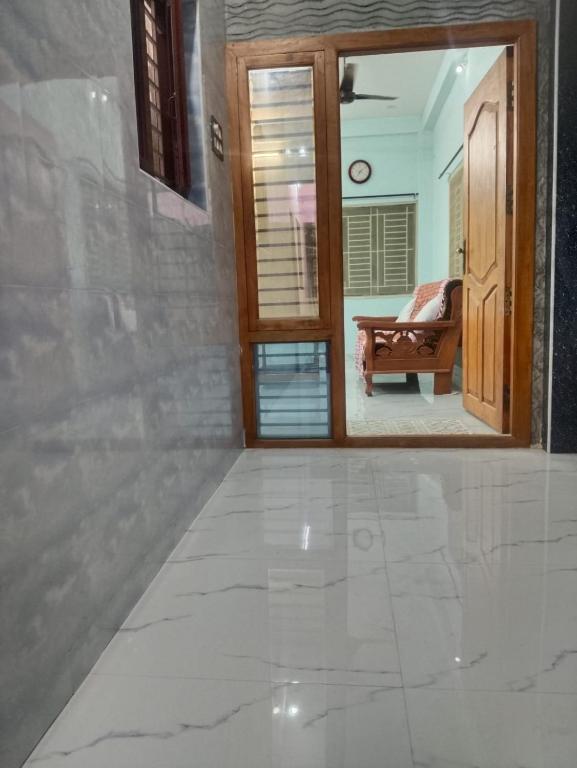 a hallway with a mirror and a room with a couch at JPR Cottage in Erode