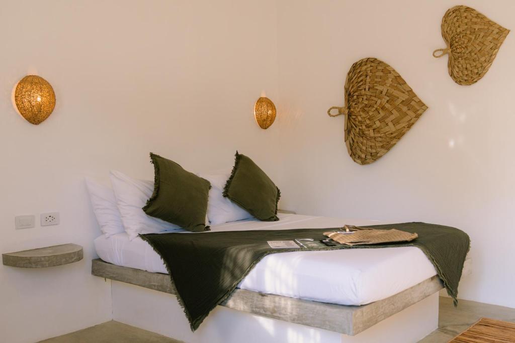 a room with a bed and a couch on a wall at SAMPA El Nido in El Nido