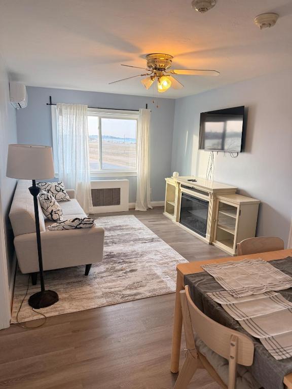 a living room with a couch a table and a television at Ocean View Cozy Stay 4 in Hull