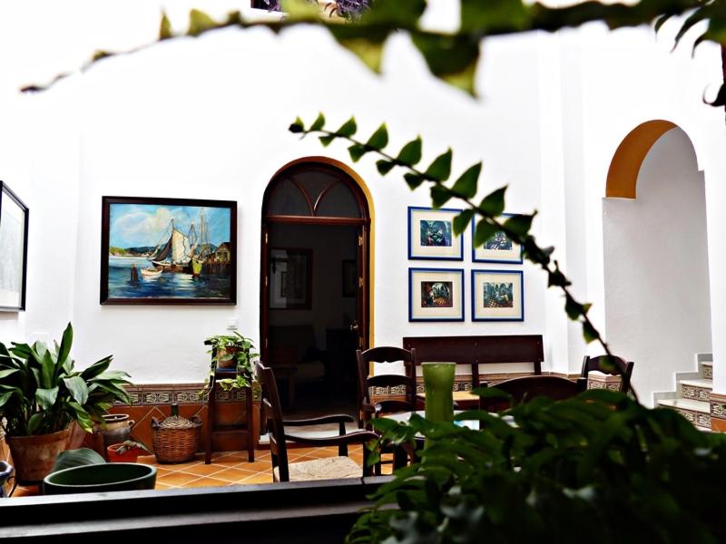 Habitación con mesa, sillas y un cuadro en la pared. en Casa Rural los dos Patios, en Arcos de la Frontera