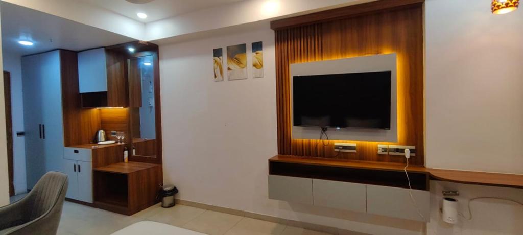 a living room with a television on a wall at RrHEAVENSTAY in Nalmatha