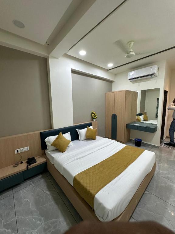 a bedroom with a large bed with yellow pillows at Hotel Embassy Inn in Ānakhol