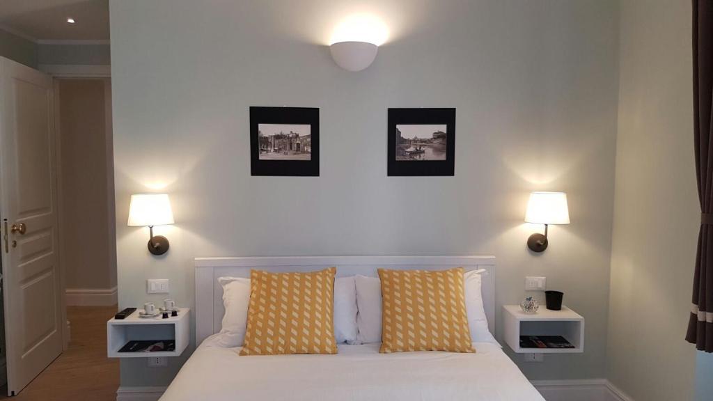 een slaapkamer met een wit bed en 2 nachtkastjes bij Roman Suite Guest House in Rome