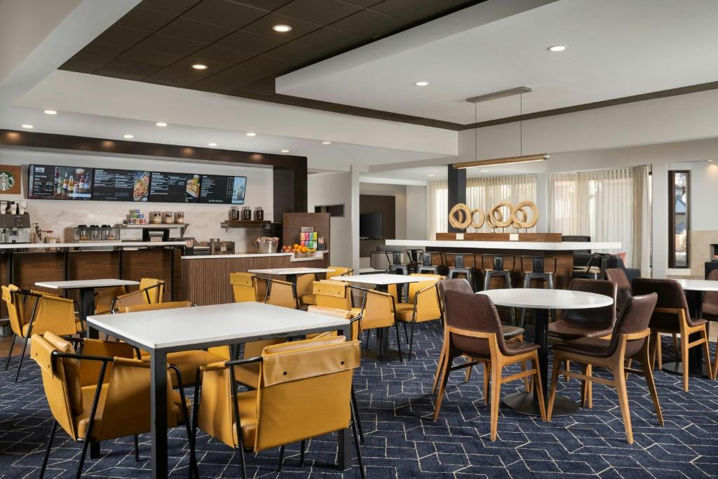 a restaurant with tables and chairs and a bar at Courtyard by Marriott Albuquerque Airport in Albuquerque
