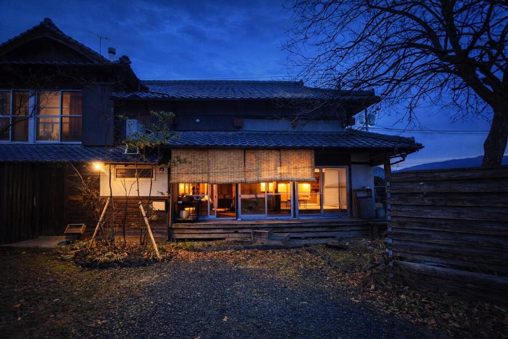 a house at night with lights on at こちの宿 in Yamaga