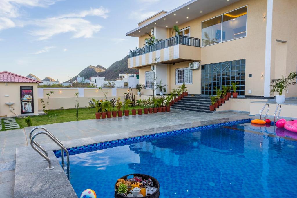 a house with a swimming pool in front of a house at Kamdhenu - Luxurious stay in Udaipur