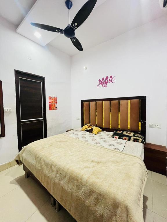 a bedroom with a large bed with a ceiling fan at Bloom Hotel in Jagādhri