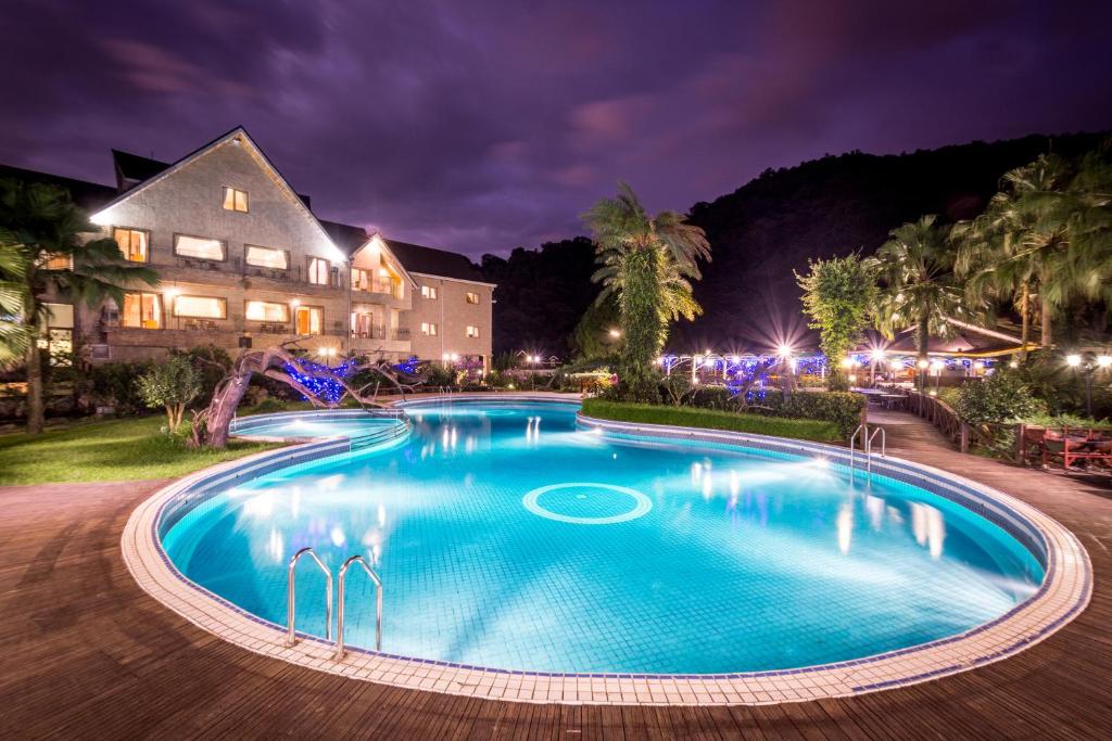 una piscina frente a una casa por la noche en We Resort, en Yuchi