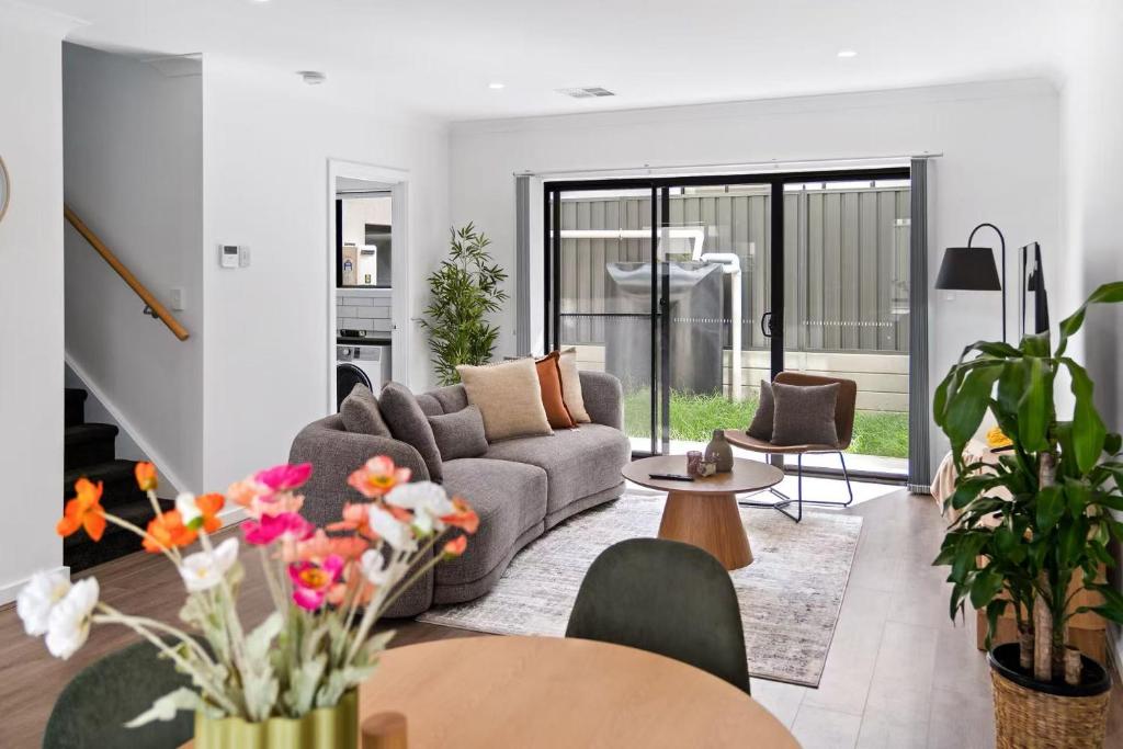 a living room with a couch and a table at Steps to the Beach Cafes moderm stylish 3BR in Christies Beach