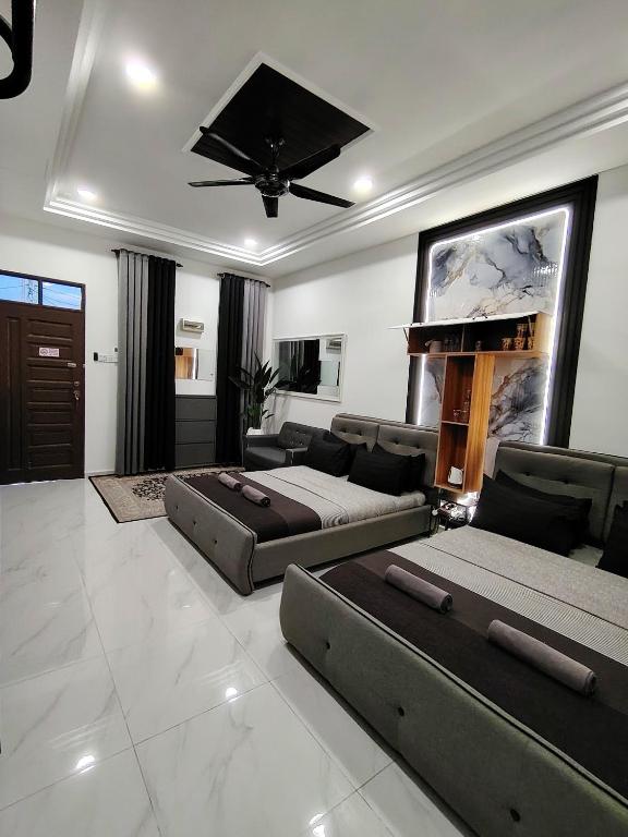 ein großes Wohnzimmer mit zwei Betten und einer Couch in der Unterkunft Mini Concept Hotel in Kuala Terengganu