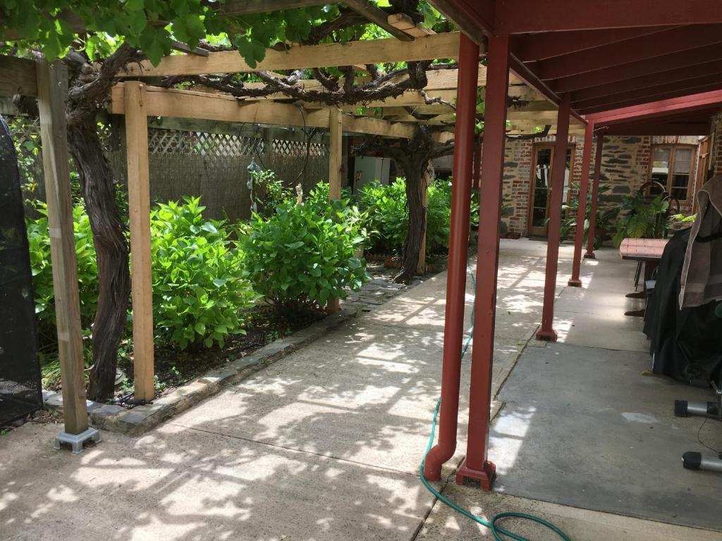 a wooden pergola with a hose on a patio at bluebird cottage in Angaston