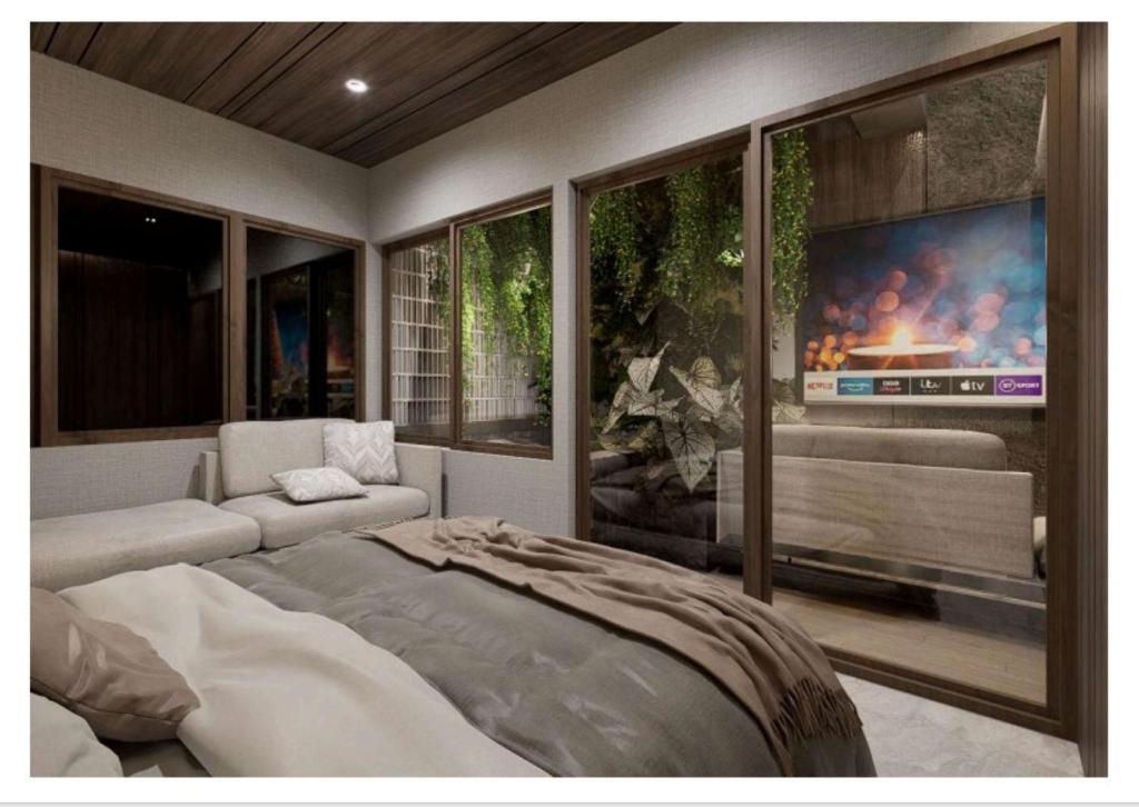 a bedroom with a bed and a large tv at The Foresta By Ohana in Timuran