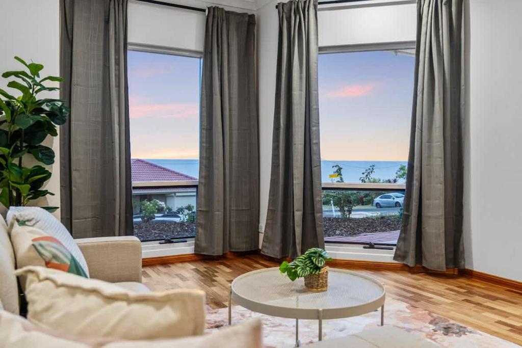 a living room with a view of the ocean at Sunset Ocean View Retreat 4BM House in Christies Beach