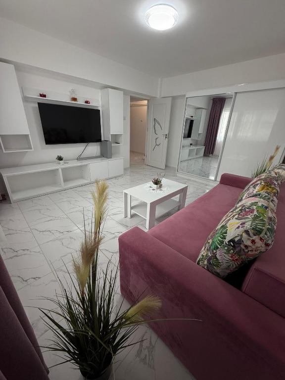 a living room with a purple couch and a tv at Anastasia in Mangalia