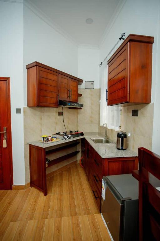 a kitchen with wooden cabinets and a counter top at Pakihotels&apartment in Moshi