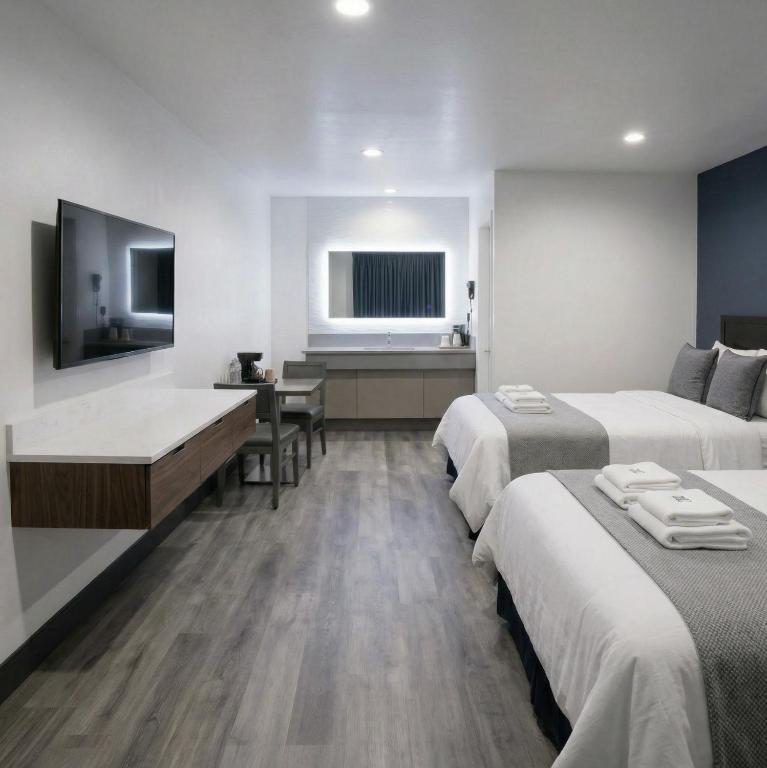 a hotel room with two beds and a television at Motel Moonlight in Anaheim