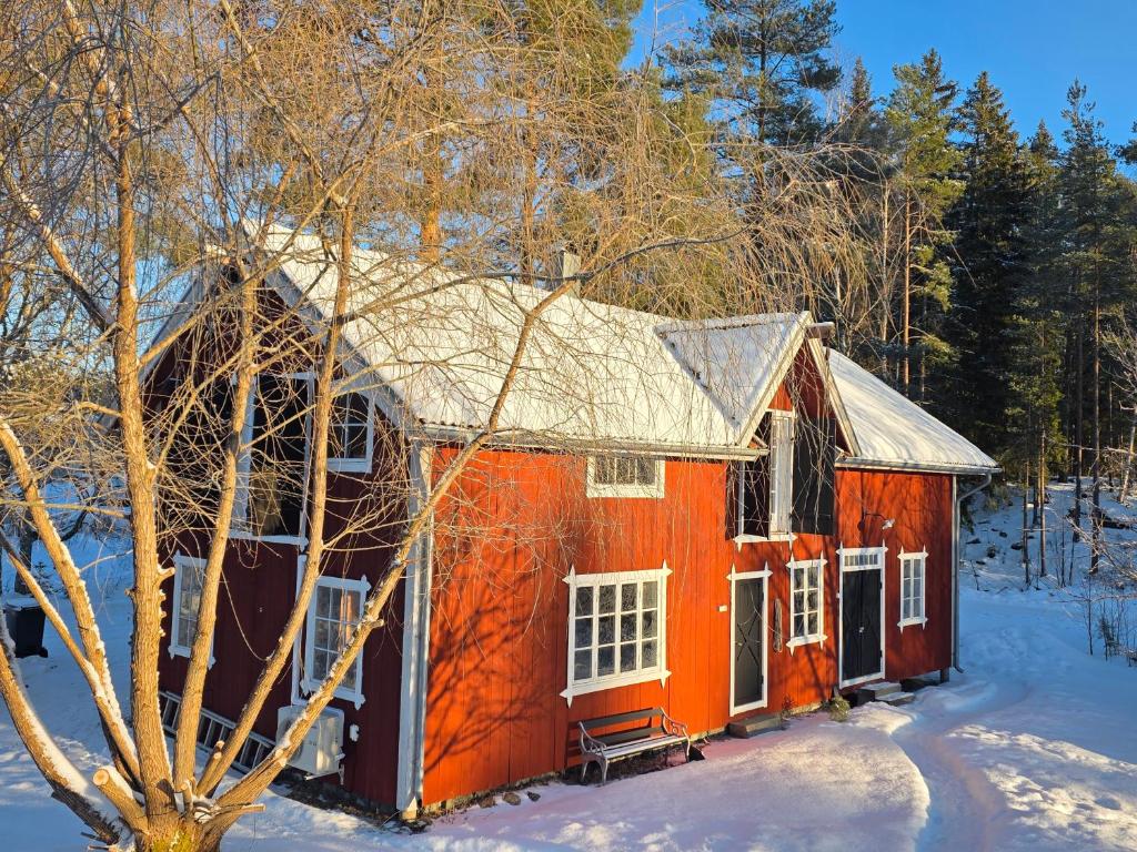 an orange house in the snow in the woods at Norra Vilan - Hagalund in Kopparberg