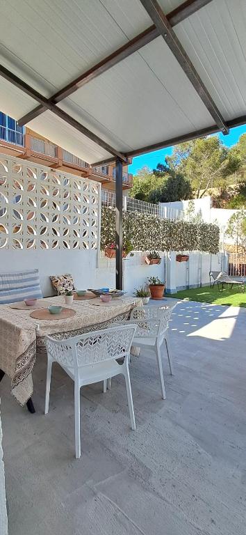 a patio with a table and chairs under a pavilion at Almirante Faro in Faro de Cullera