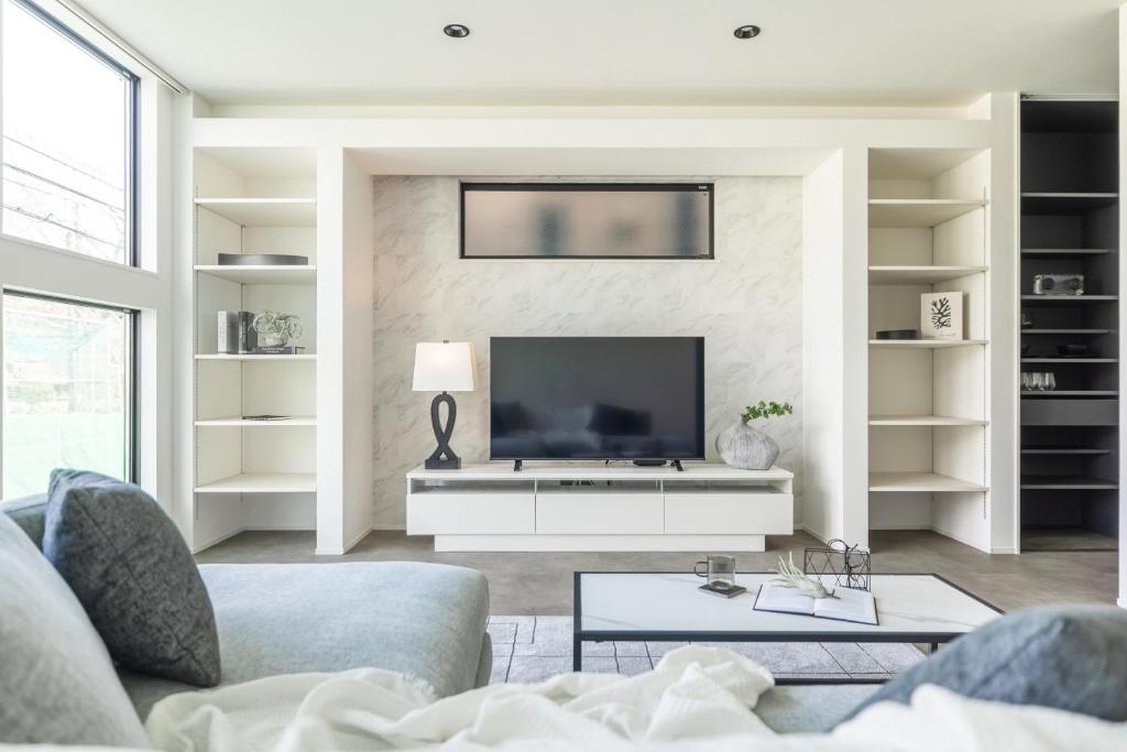a living room with a couch and a tv at Charm Roger Luxury Room 2 in Kamakura