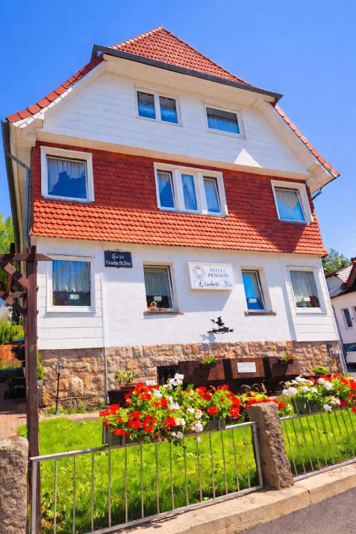 a house with flowers in front of a fence at Hotel Elisabeth Ilse in Braunlage