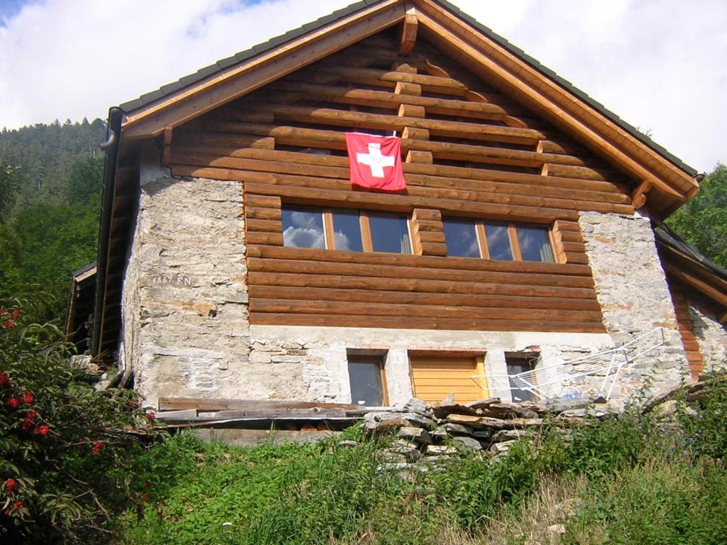 a log house with a canadian flag on the side of it at Bellissimo Chalet con vista in Faido