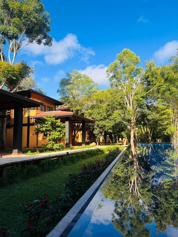 a villa with a swimming pool and a house at Aria Resort in Sigiriya