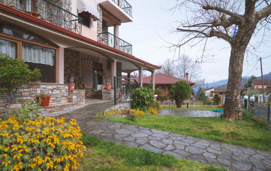 a house with yellow flowers in the yard at Thermora Hotel in Orma