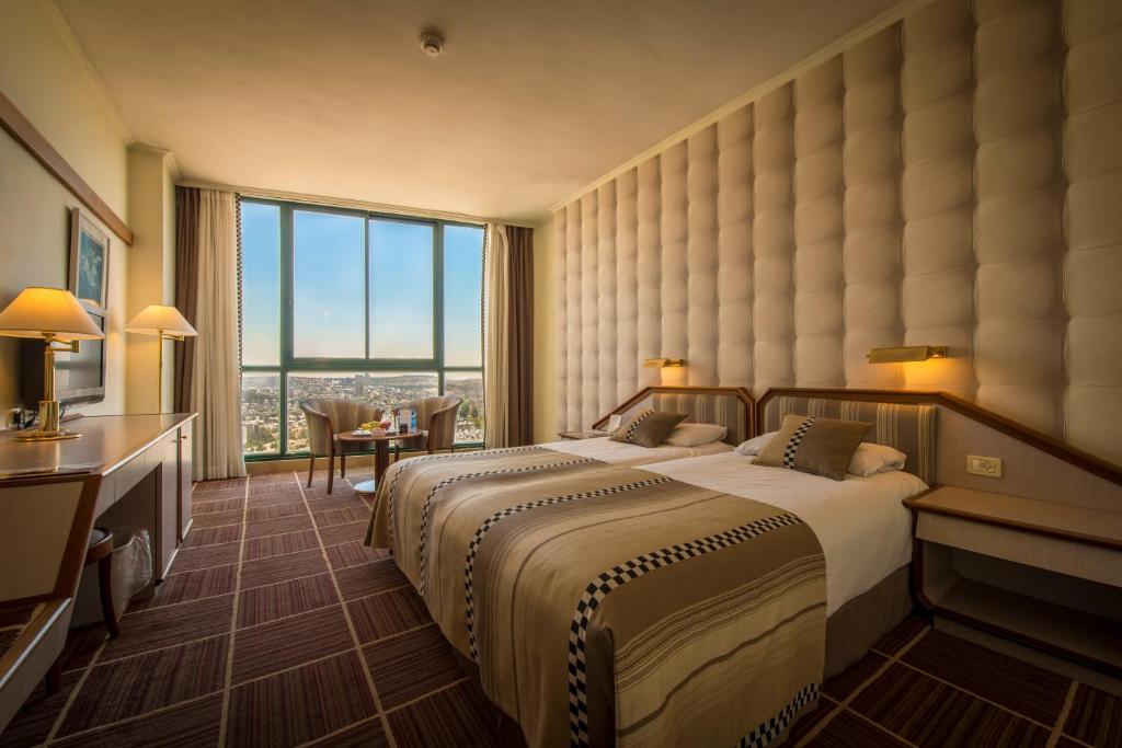 a hotel room with a bed and a large window at Shalom Jerusalem Hotel in Jerusalem