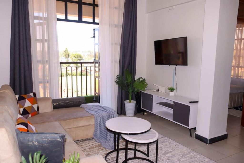 a living room with a couch and a tv at Gessy Homes in Eldoret