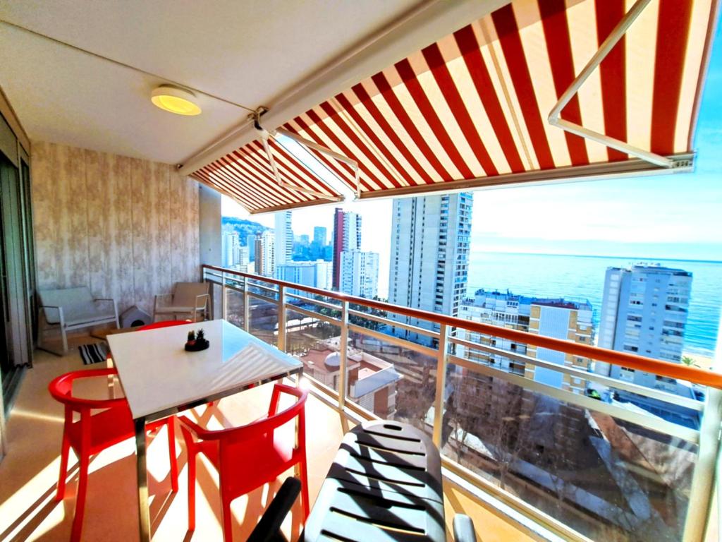 a balcony with a table and chairs and a view of the city at Coblanca 41-spectacular views-gym-heated pool-sauna-jacuzzi-wifi-3 minutes walk from the sear in Benidorm