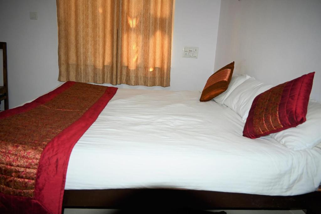 a bedroom with a large bed with white sheets and pillows at Amar Bagh Ranthambore in Khilchipur