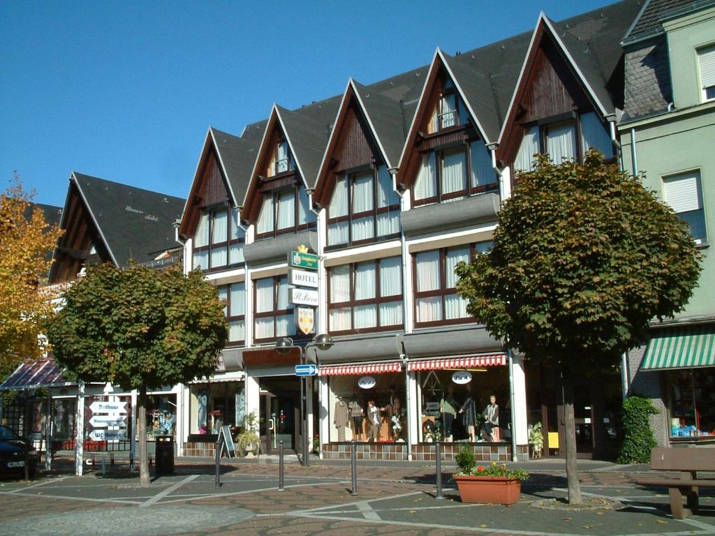 ein großes Gebäude mit Spitzdächern an einer Stadtstraße in der Unterkunft Hotel St. Pierre in Bad Hönningen