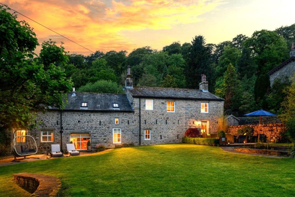 an old stone house with a large yard at Carrholme Cottage in Settle