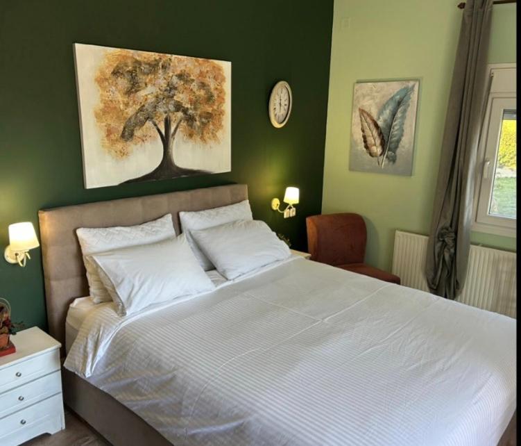 a bedroom with a bed with a tree on the wall at Akrotiri Studios in Samothraki