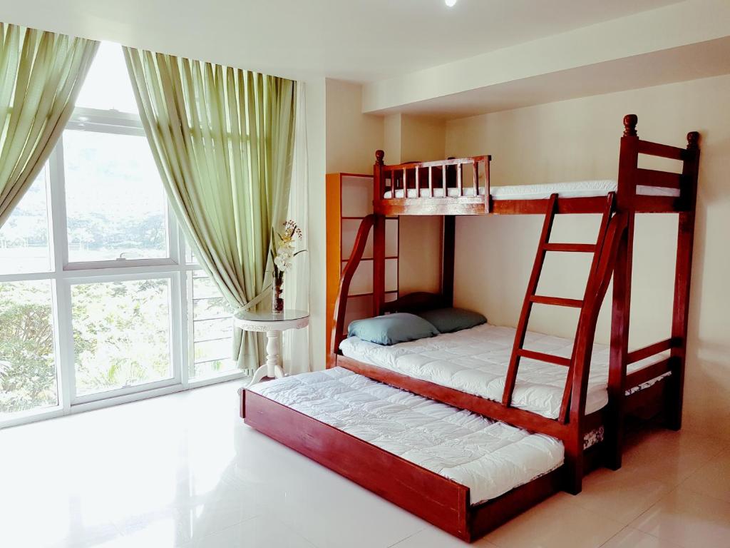 Ce dortoir comprend 2 lits superposés et une fenêtre. dans l'établissement Myna Lagoon Pico de Loro, à Nasugbu