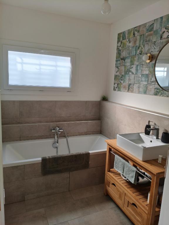 a bathroom with a tub and a sink at Chambre privée Orthez in Orthez