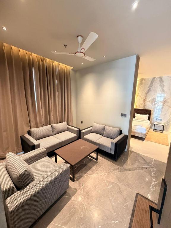 a living room with two couches and a bed at Hotel The Unify in Jāmb