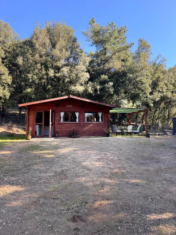 a small cabin with a porch and a pavilion at Can Cospito in Osor