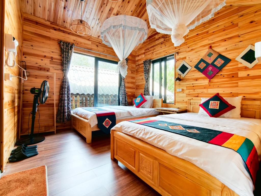 a bedroom with two beds in a log cabin at River mountain view homestay in Sapa