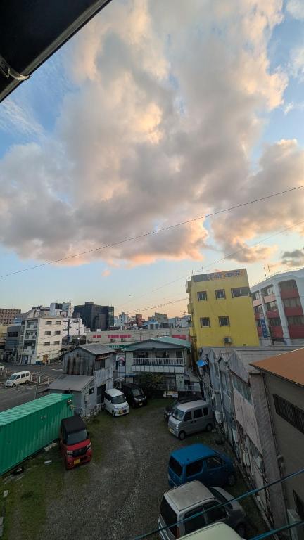 a city with cars parked in a parking lot at 奄美ザナゼステイTheNazeStay in Amami